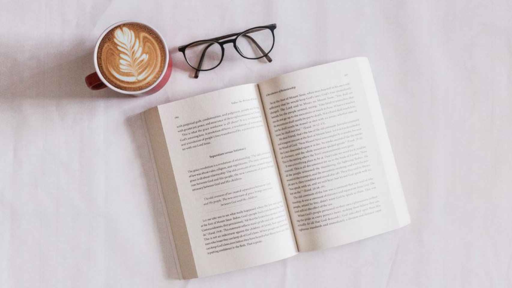 Taza de café, gafas, y libro abierto preparado para su lectura / UNSPLASH