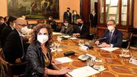 El consejero de Economía de la Generalitat, Jaume Giró (d) y la ministra de Hacienda, María Jesús Montero (en primer término)