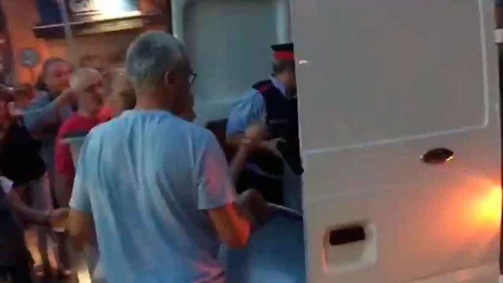 La pareja de mossos, cargando urnas en una furgoneta ante una multitud entregada / CG