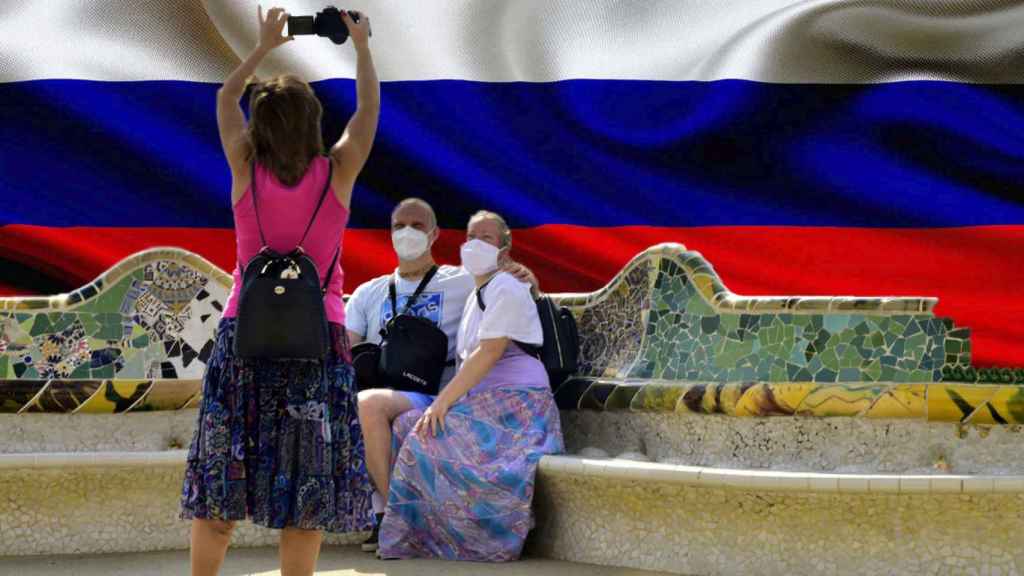 Turistas en Barcelona junto a la bandera de Rusia.