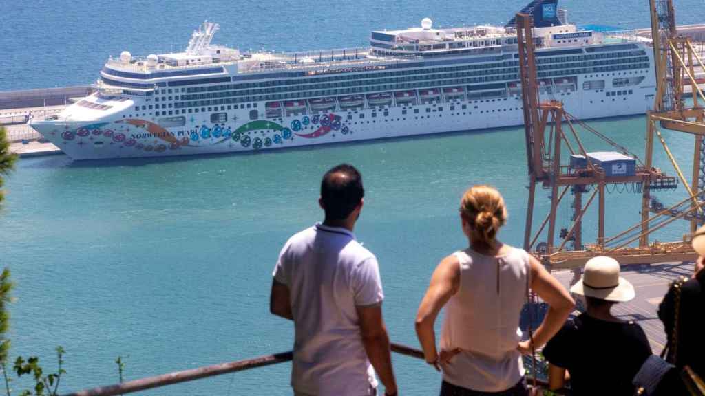 Varias personas observan un crucero que hace escala en el Puerto de Barcelona / EFE