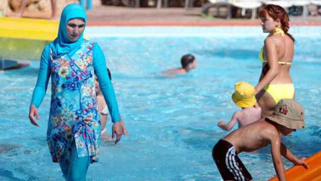 Una mujer con burkini en una piscina, foto de archivo / TUISTISLAMOPHOBIA