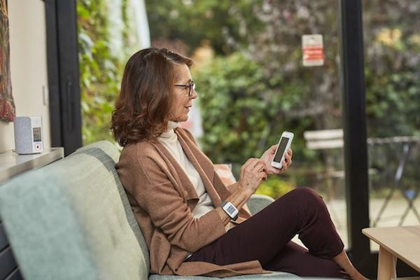 Una mujer con el reloj de Securitas Direct y su smartphone