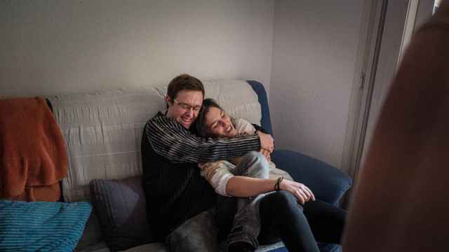 Eloi (i) abraza a su compañera de piso Anna (d) en el sofá del comedor de la vivienda gestionada por el programa de integración para personas con síndrome de Down de la Universitat de Vic / PABLO MIRANZO (CG)