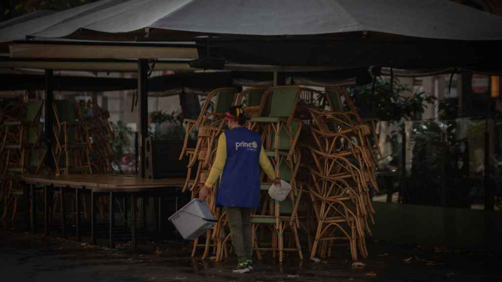 Una mujer limpia la terraza de un bar durante las restricciones por coronavirus / EP