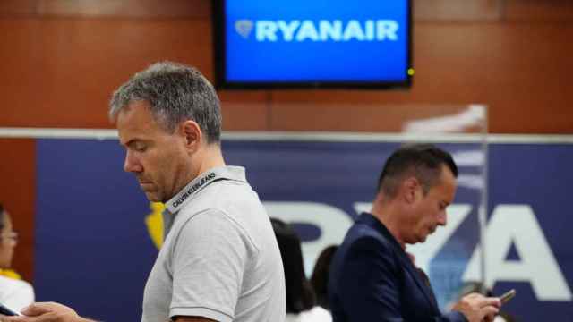 Un hombre afectado por la huelga de Ryanair comprueba el estado de su vuelo en El Prat / EFE