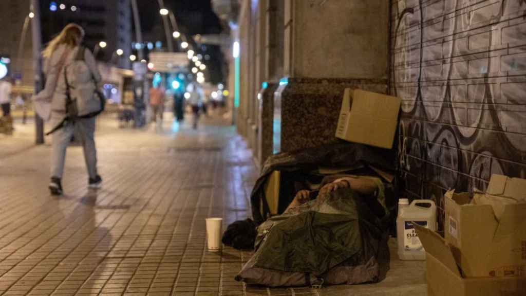 Una persona sin hogar duerme en una calle de Barcelona / KIKE RINCÓN - EUROPA PRESS