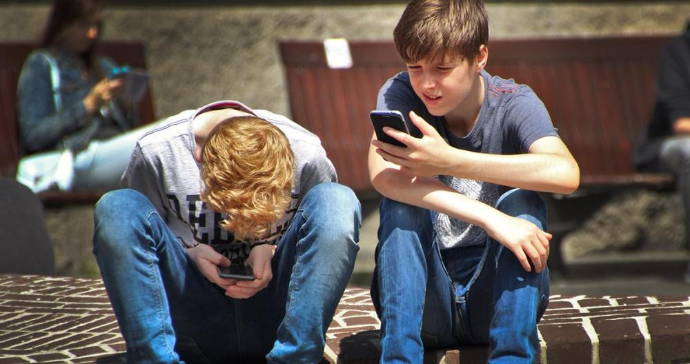 Dos chicos adolescentes juegan con sus smartphones / PEXELS