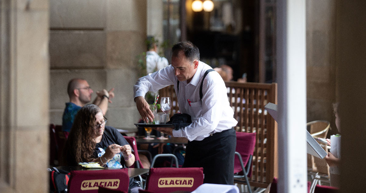 Un trabajador de la hostelería en la plaza Real de Barcelona / DAVID ZORRAKINO - EP