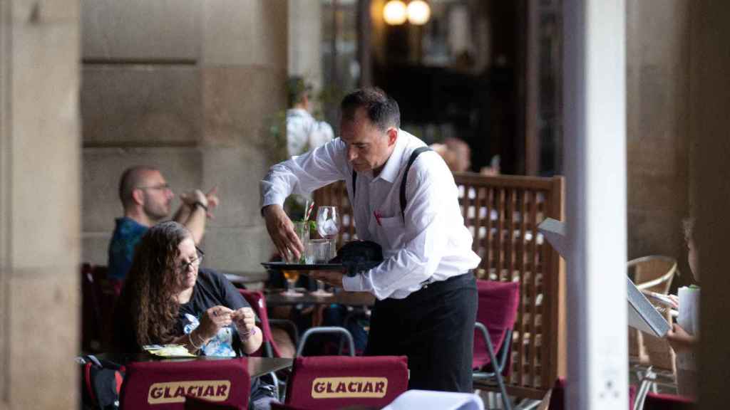 Un trabajador de la hostelería en la plaza Real de Barcelona / DAVID ZORRAKINO - EP