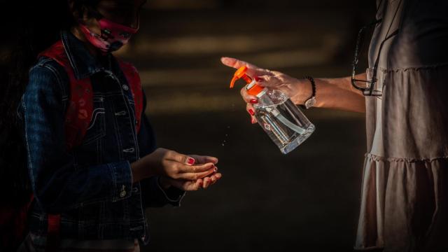 Un progresora aplica gel a una alumna en uno de los colegios de Cataluña / EP