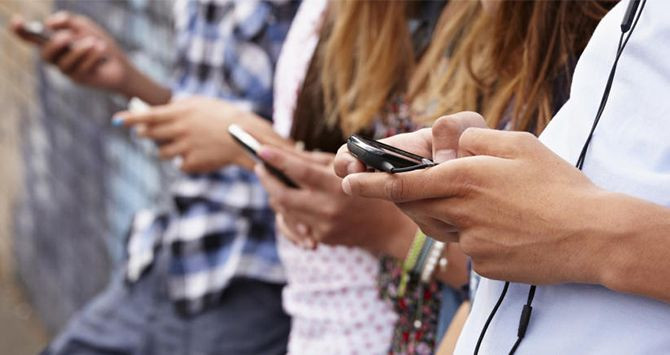 Jóvenes usando su teléfono móvil / CG