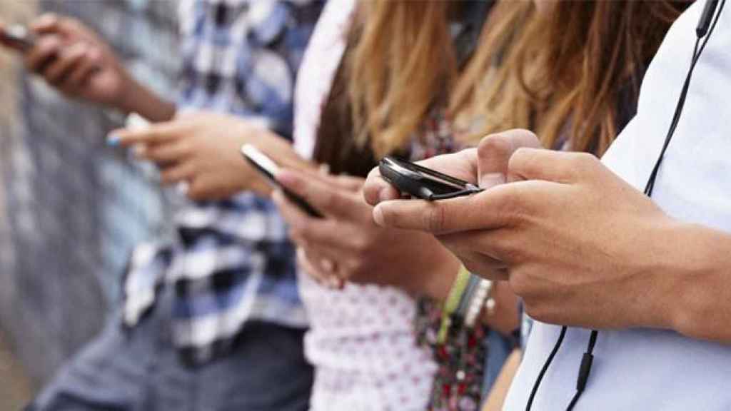 Jóvenes usando su teléfono móvil / CG