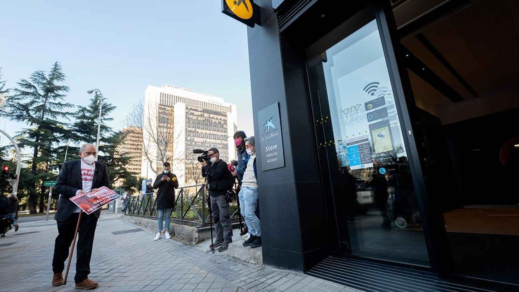 Carlos San Juan, promotor de la campaña 'Soy mayor, no idiota' en apoyo a los mayores, ante una sucursal bancaria de Caixabank / Alberto Ortega (EP)