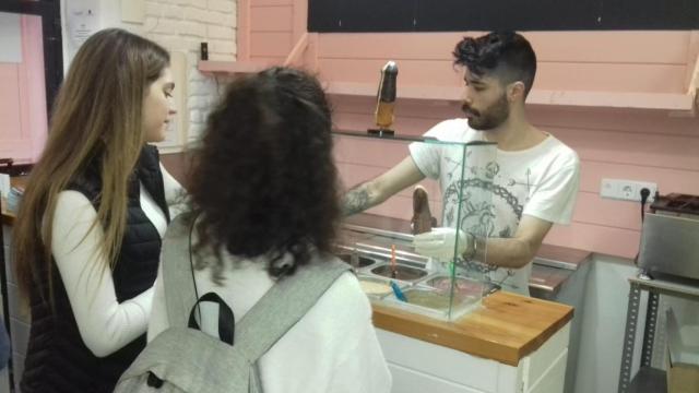 Raúl atiende a dos chicas que acudieron a comerse un ‘pollofre’ a La Pollería / LUIS M. GARCÍA