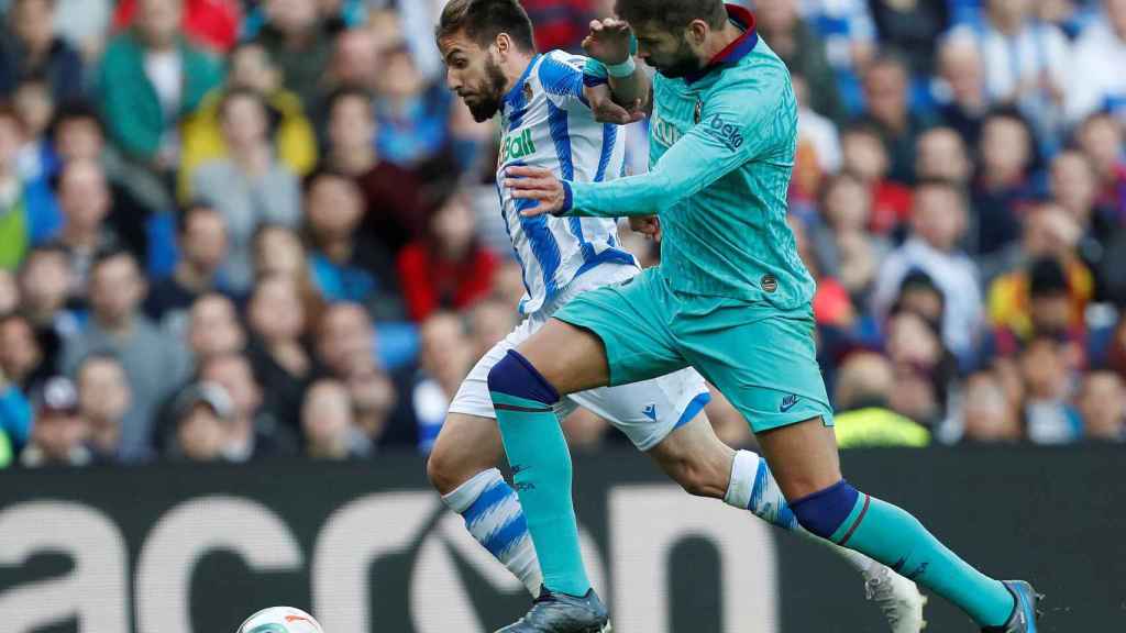 Piqué frena a Portu en el partido contra la Real Sociedad / EFE