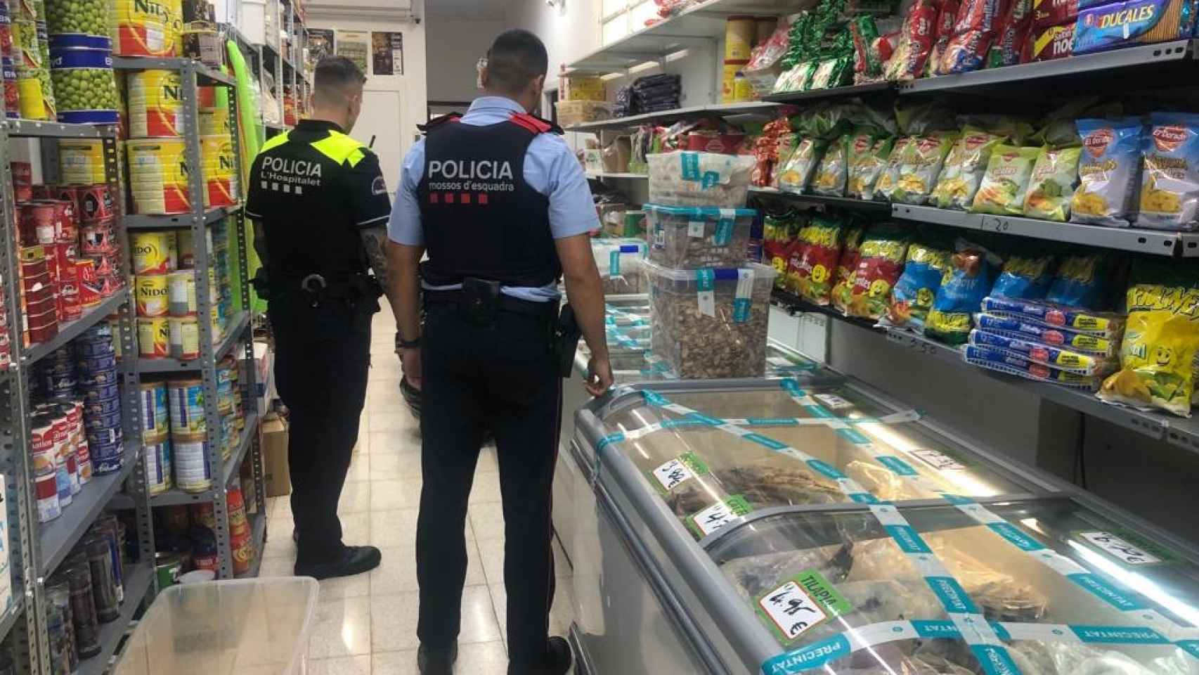 Momento de la inspección sanitaria de Mossos d'Esquadra y Guardia Urbana a un comercio que vendía alimentos en mal estado en L’Hospitalet de Llobregat / AJUNTAMENT DE L'HOSPITALET