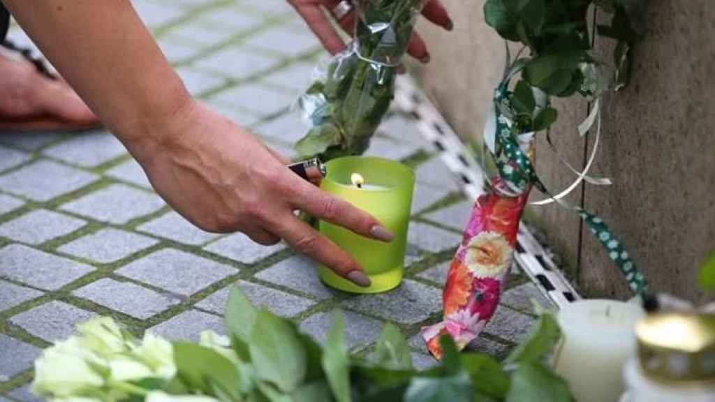 Una mujer enciende una vela en el homenaje a las víctimas mortales del atentado en Munich.