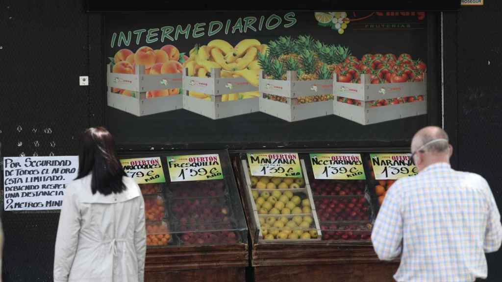 Personas miran los precios de la fruta / EP