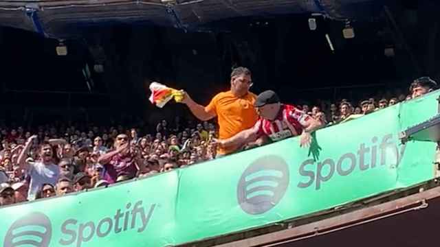 Un aficionado del Barça quita una bandera a uno del Atlético en el Camp Nou / REDES