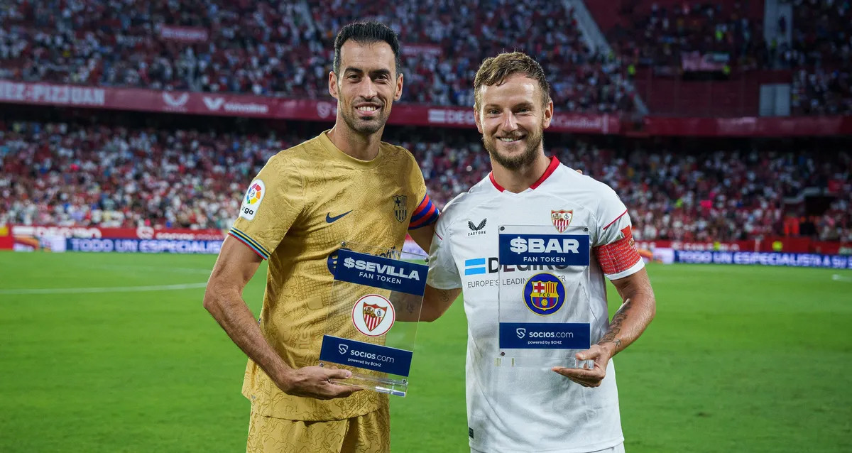 Busquets y Rakitic, sosteniendo un activo de Fan Tokens, en la previa del Sevilla-Barça / FCB