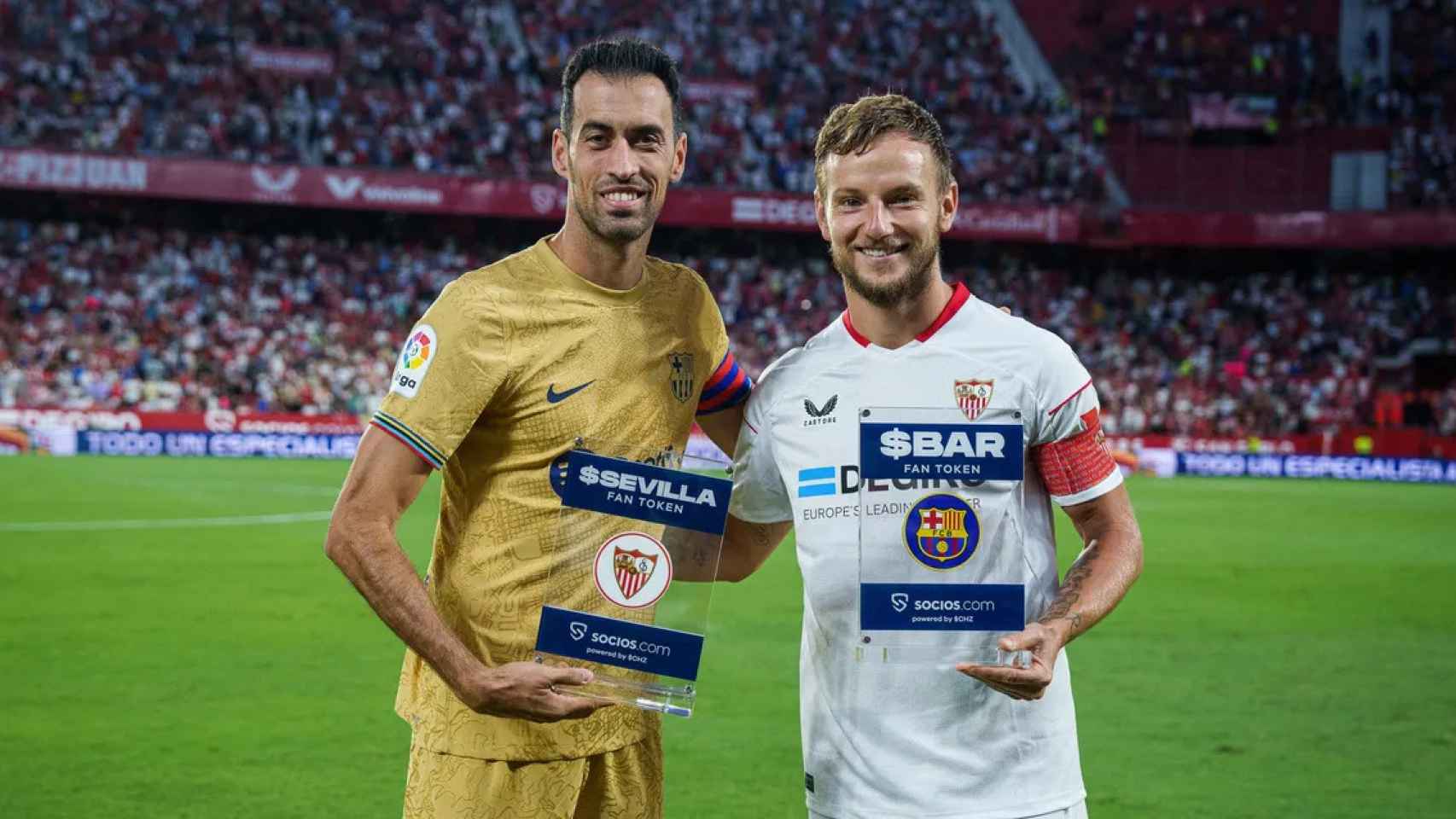 Busquets y Rakitic, sosteniendo un activo de Fan Tokens, en la previa del Sevilla-Barça / FCB