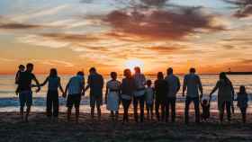 Familias contemplando una puesta de sol en la playa