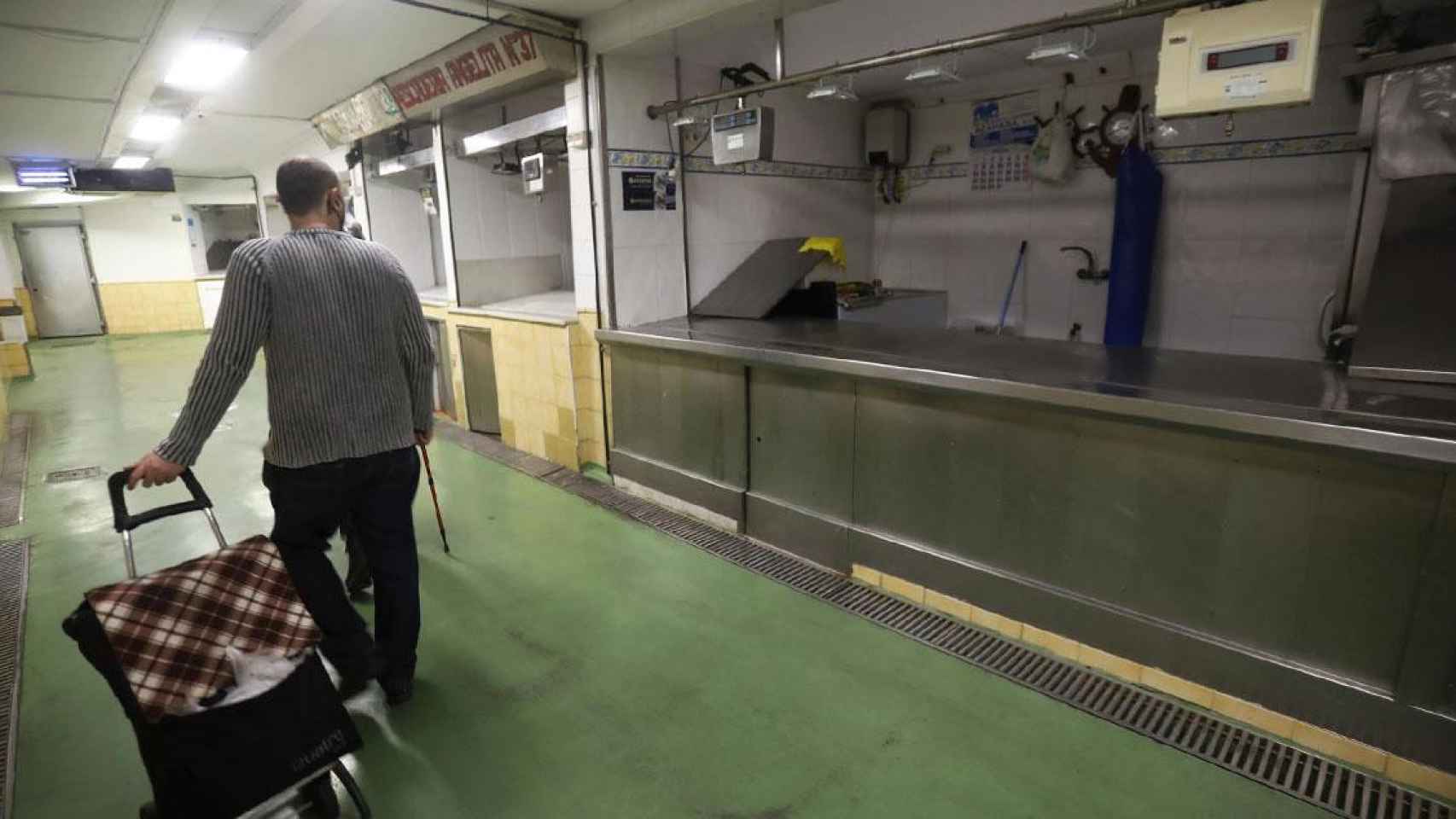 Una persona camina junto a varios puestos de pescado vacíos en un mercado de Córdoba debido a los problemas de suminstro de productos por la huelga de transportistas / Salas (EFE)