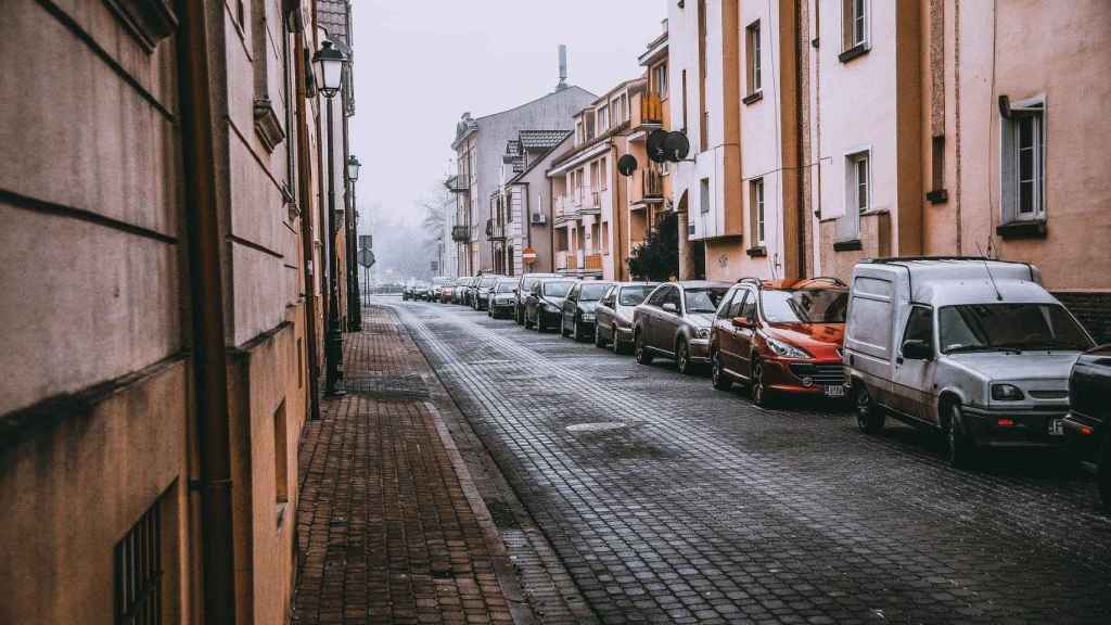 Una hilera de coches aparcados en una acera / CG