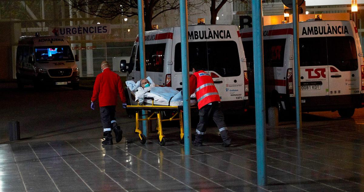 Dos sanitarios entrando a un paciente de edad avanzada en un hospital de Barcelona / EFE