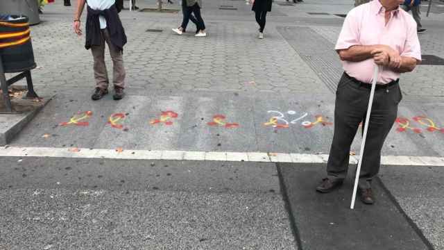 Lazos con los colores de la bandera de España pintados en el suelo de Paseo de Gràcia durante el 12-O / CRÓNICA GLOBAL