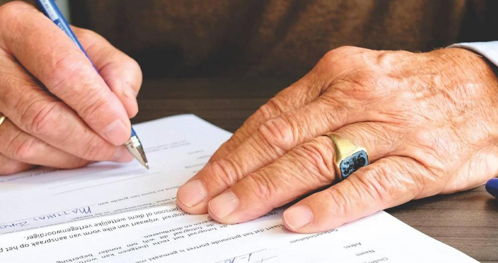 Un hombre firma un testamento / PEXELS
