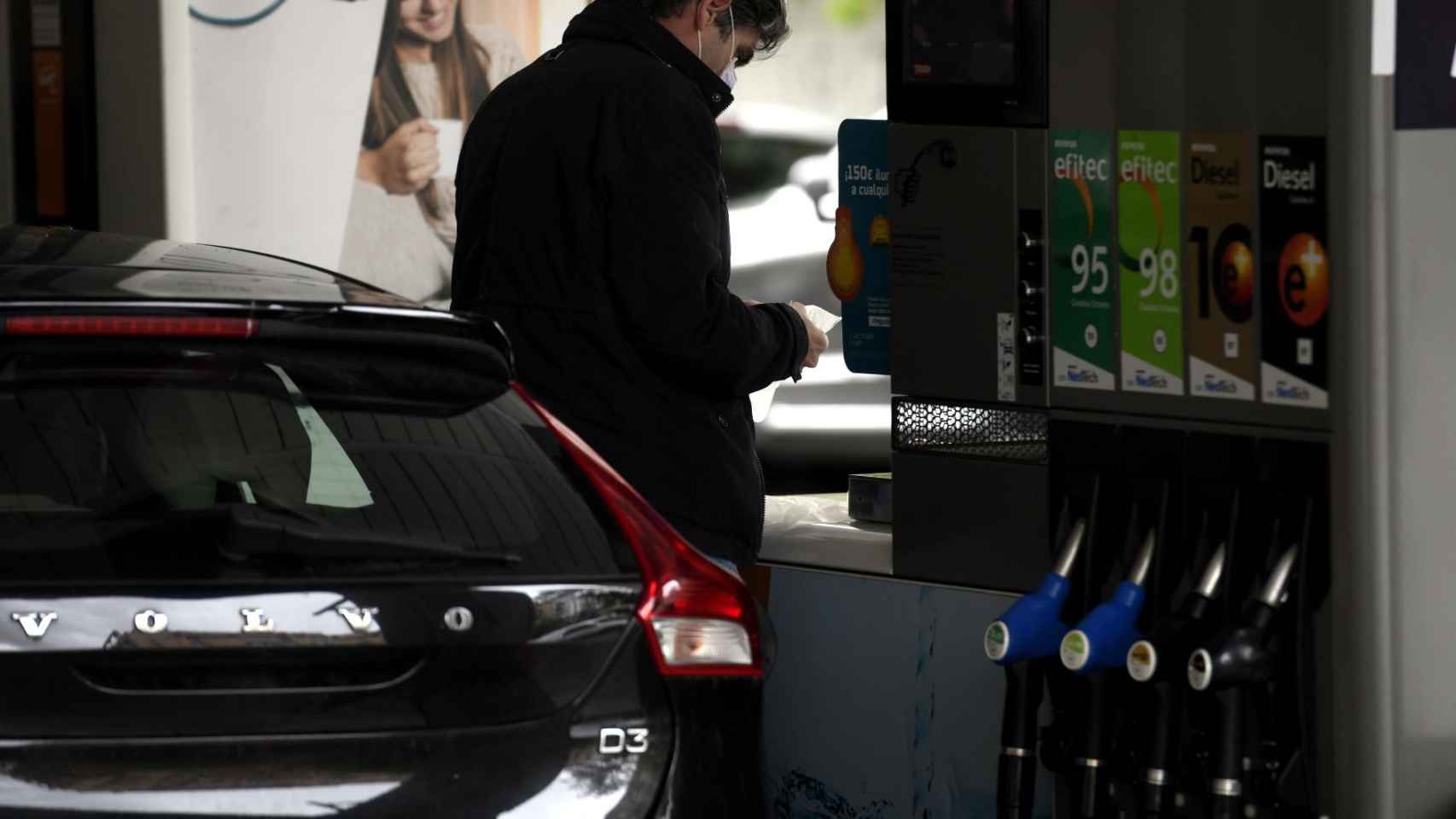 Un conductor reposta su vehículo en una estación de servicio / EP