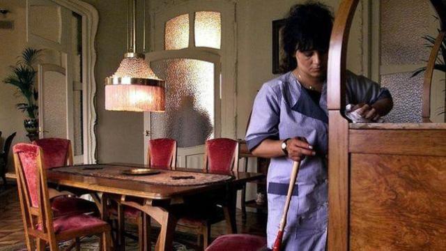 Una trabajadora limpiando el comedor de una vivienda / EFE