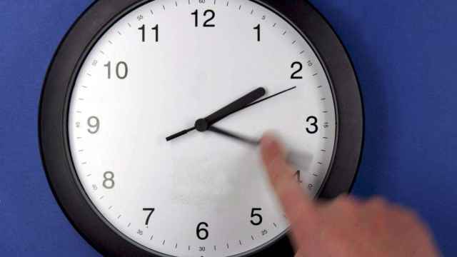Una persona cambia la hora del reloj de las 3 a las 2 / EFE