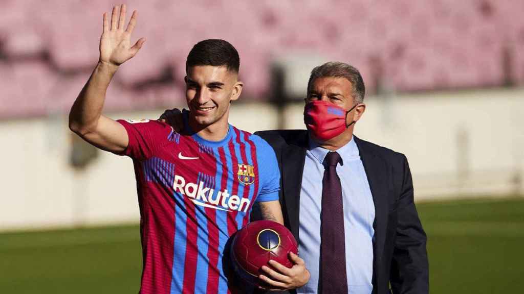 Ferran Torres, abrazado por Laporta, saluda a la afición del Barça en su presentación / EFE