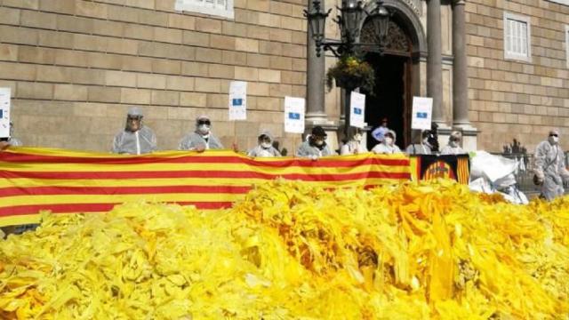 Miles de lazos amarillos volcados por Els Segadors del Maresme ante el Palau de la Generalitat, una acción que vigilan los Mossos / ELS SEGADORS DEL MARESME