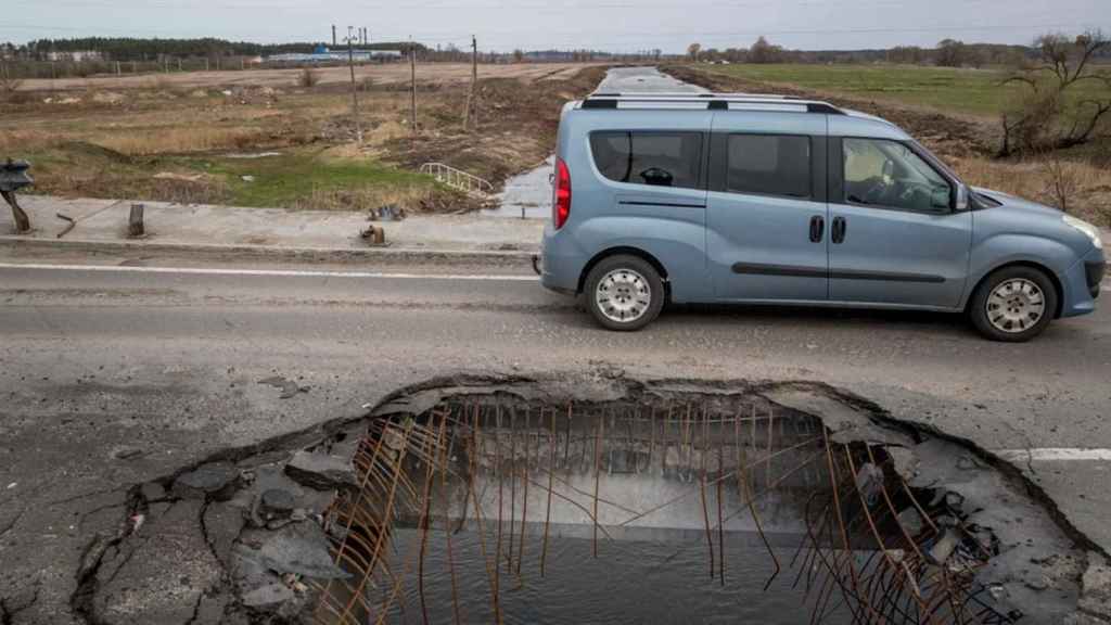 Un coche pasa por un puente destrozado por proyectiles en Bucha, cerca de la capital ucraniana, Kiev / MIGUEL GUTIÉRREZ - EFE