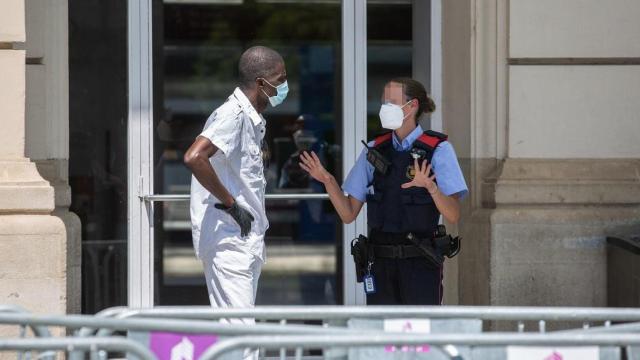 Un Mosso d'Esquadra habla con un temporero en la entrada de la Estación de Tren de Lleida / EP