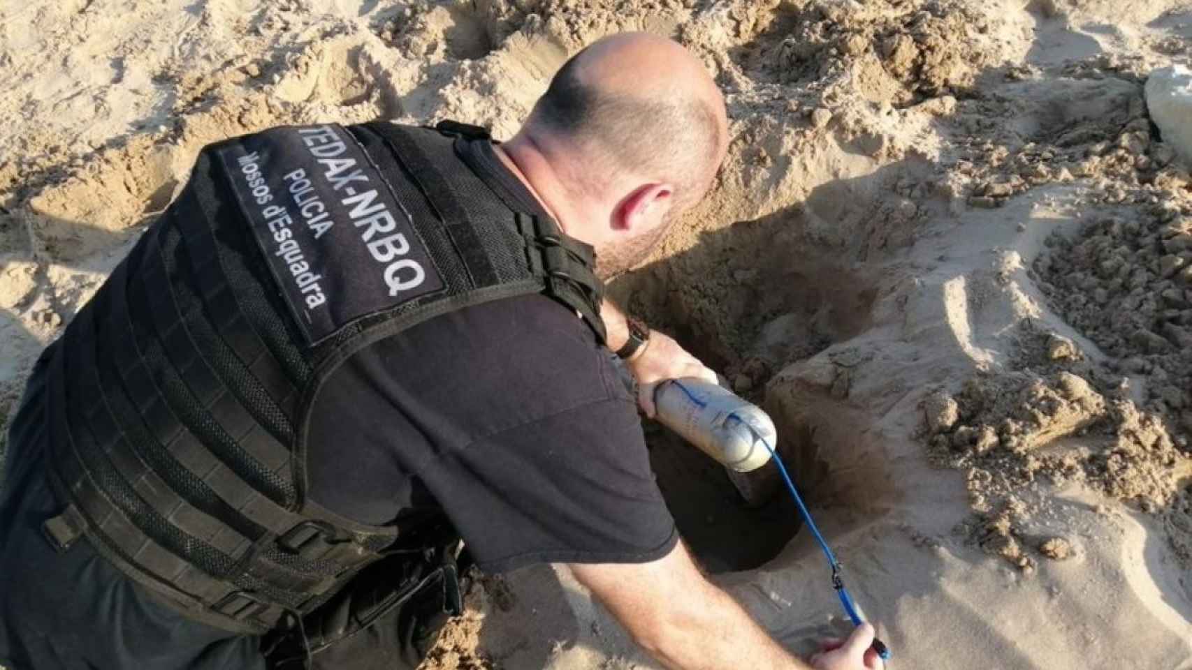 Un Mosso d'Esquadra miembro de los Tedax analiza el explosivo hallado en la playa de la Arrabassada, en Tarragona / EP