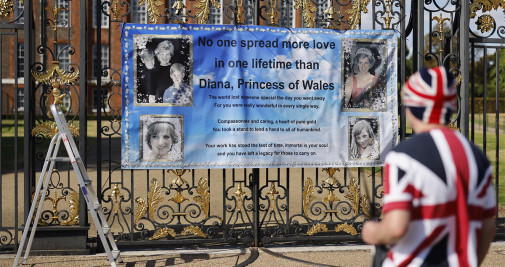 El fan de Diana de Gales John Loughrey coloca un poster en las rejas del Palacio de Kensington en Londres (Reino Unido) - EFE/EPA/TOLGA AKMEN