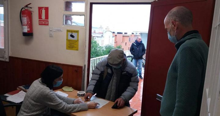 Personas en situación de vulnerabilidad recogen alimentos en Cáritas Barcelona / CÁRITAS