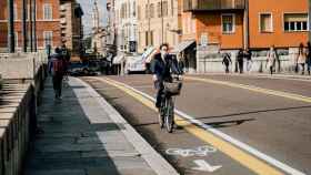 Mujer circulando con su bicicleta en un carril bici / Gabriella Clare Marino en UNSPLASH