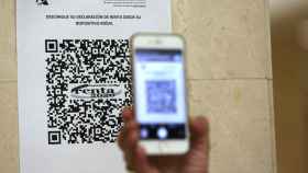 Una persona muestra un código QR con el que acceder a la declaración de la Renta 2020 dentro de una oficina de la Agencia Tributaria / EUROPA PRESS