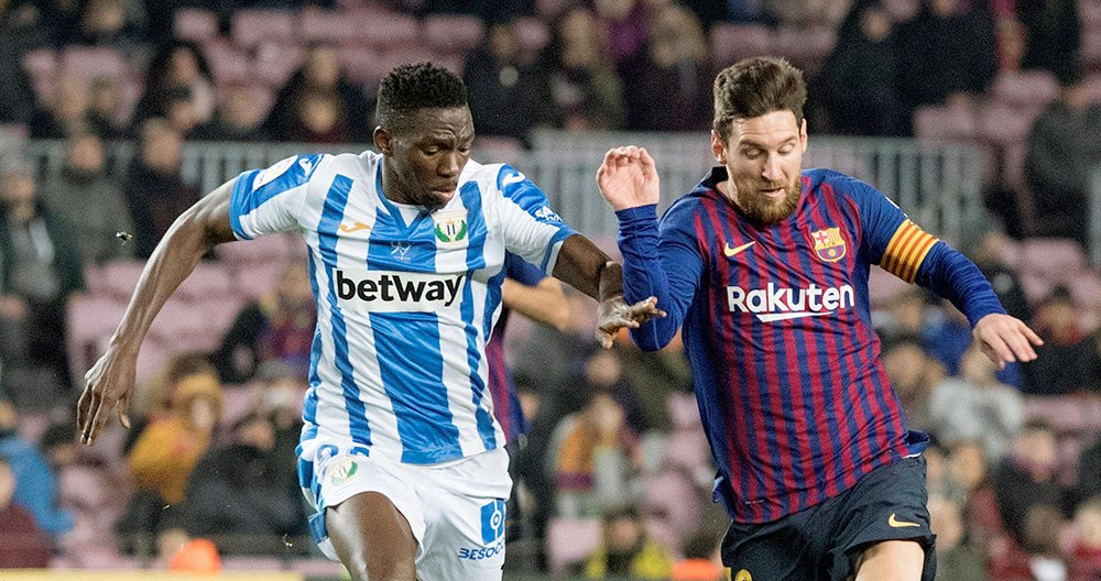 El delantero del Barça Leo Messi (d) se escapa del nigeriano Kenneth Omeruo, del CD Leganés, en un Camp Nou con muchos asientos libres / EFE