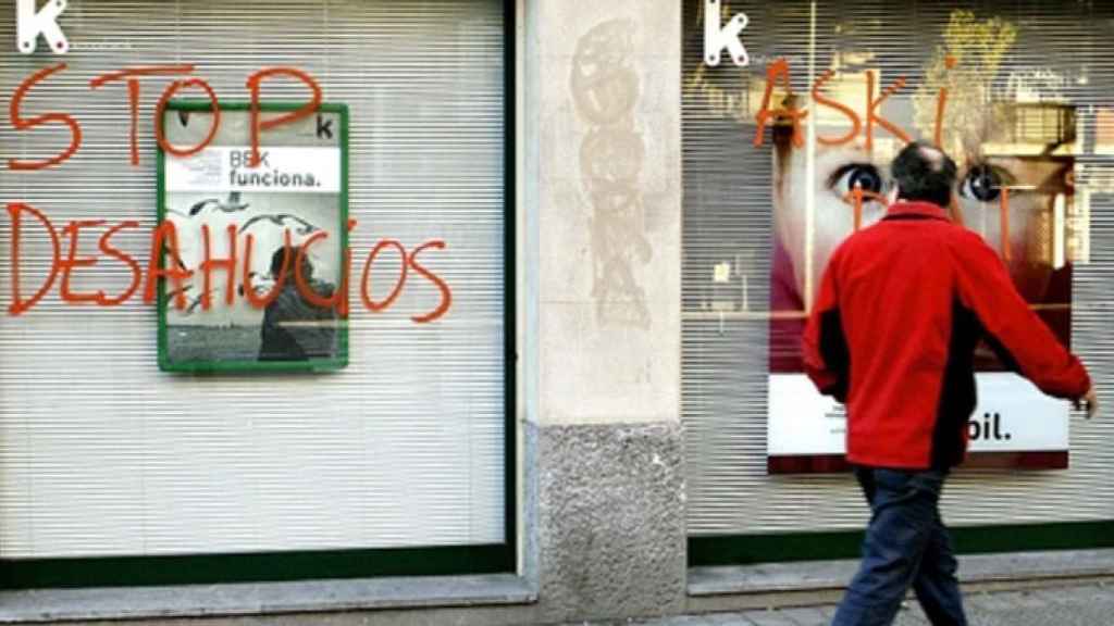 Una sede bancaria con una pintada contra los desahucios en vivienda, último paso de las ejecuciones hipotecarias / EFE