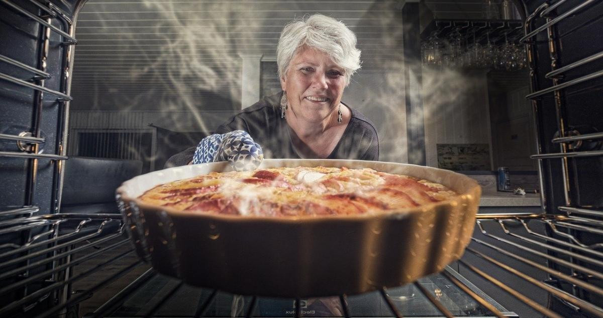 Una mujer saca del horno un pastel de manzana hecho con harina y levadura / PIXABAY