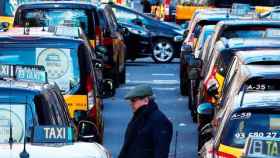 Imagen de un transeúnte pasando por la Gran Via de Barcelona en plena protesta de los taxistas / CG