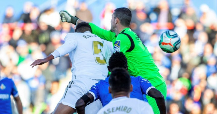 Varane rematando el balón ante la mala salida de Soria / EFE