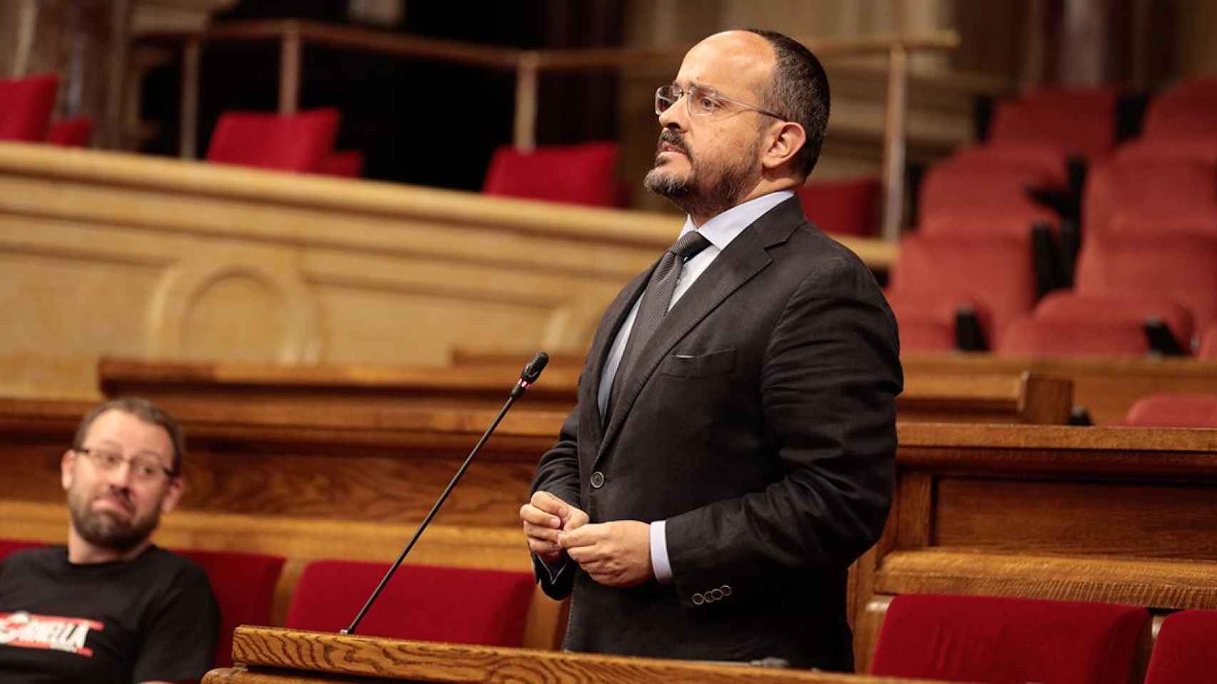 El presidente del PPC, Alejandro Fernández, en su escaño del Parlament, observado por el diputado de la CUP Vidal Aragonès / JOB VERMEULEN